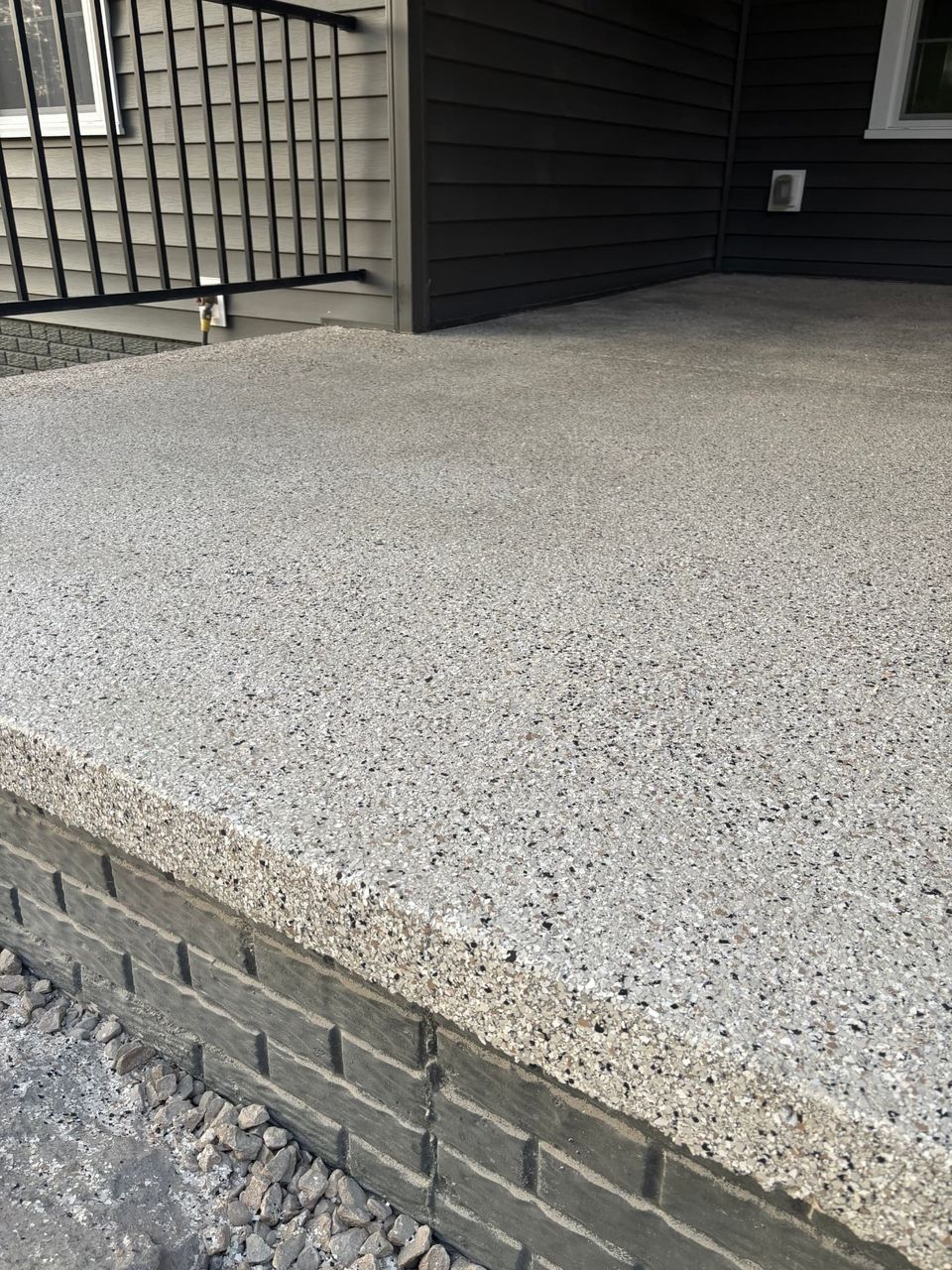 Exposed aggregate pebble finish on a covered porch step by SurfaceKings